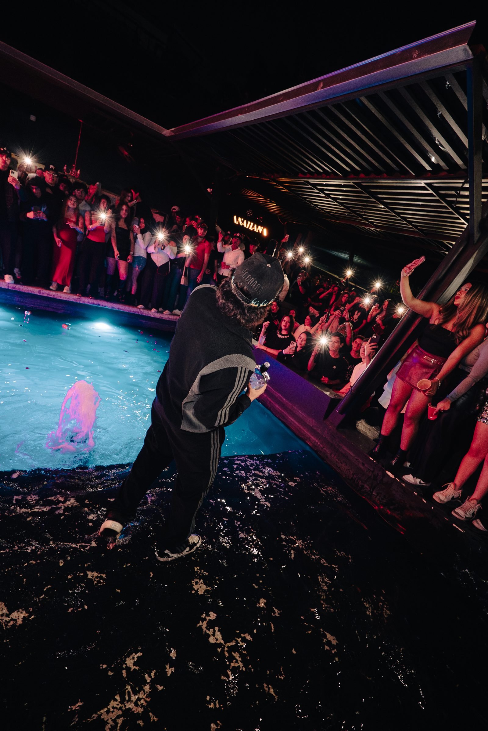 Jimmy Guzmán en un show al aire libre junto a la alberca, rodeado de asistentes