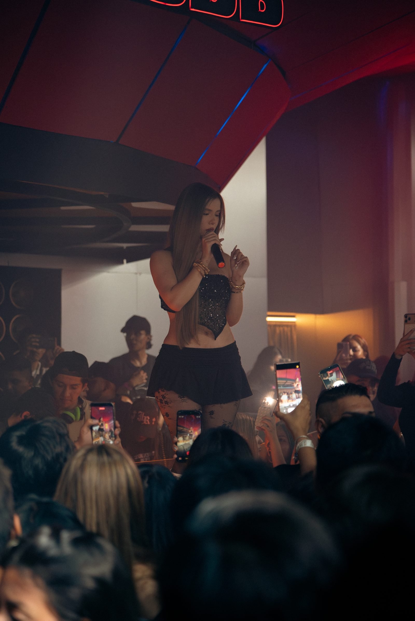 Miranda León de pie sobre la plataforma cantando frente al público